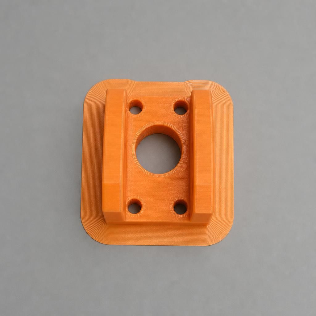 Peça impressa em 3D com brim ao redor da base ancorando os cantos na mesa