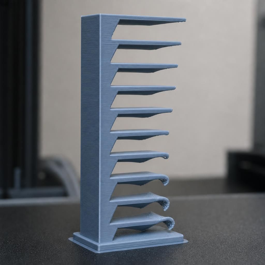 Torre de teste de overhang em impressão 3D mostrando ângulos crescentes que começam a enrolar