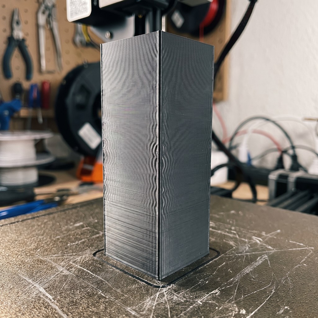 Peça alta e estreita impressa em 3D com ondulação de ghosting visível na parede lateral